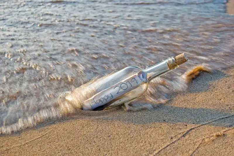 new-year-message-bottle-wave-beach-sand-120404540.webp